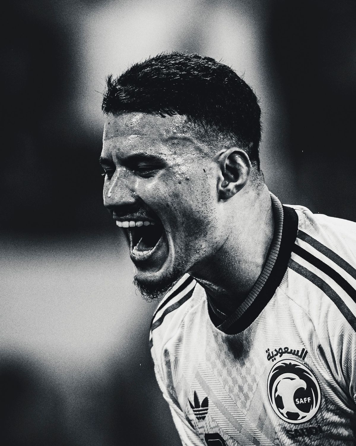 Black and white portrait of a soccer player screaming in celebration