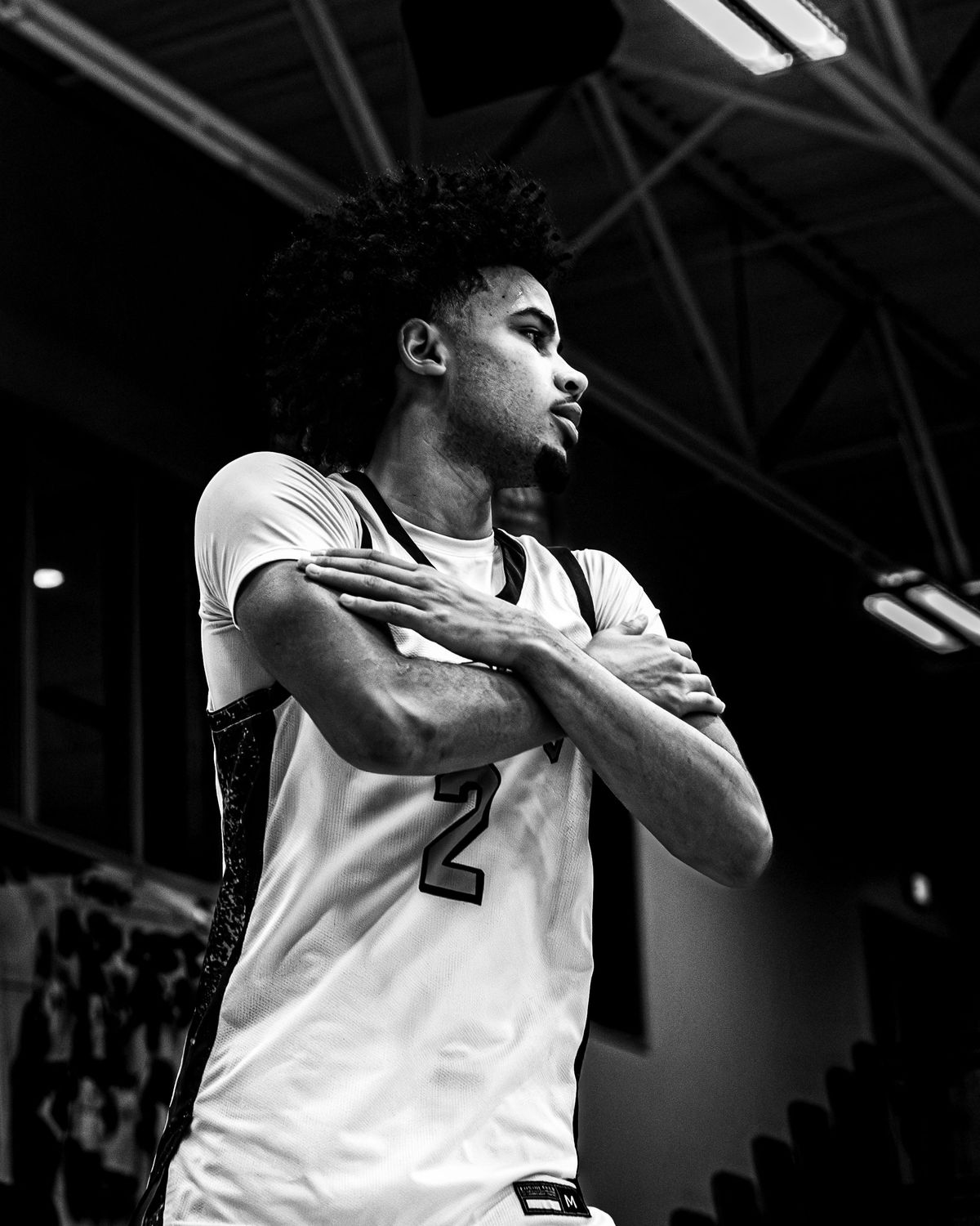 Basketball player in a white number 2 jersey crossing his arms, black and white