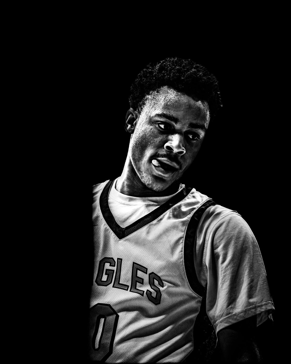 Basketball player in an Eagles jersey looking over his shoulder, black and white