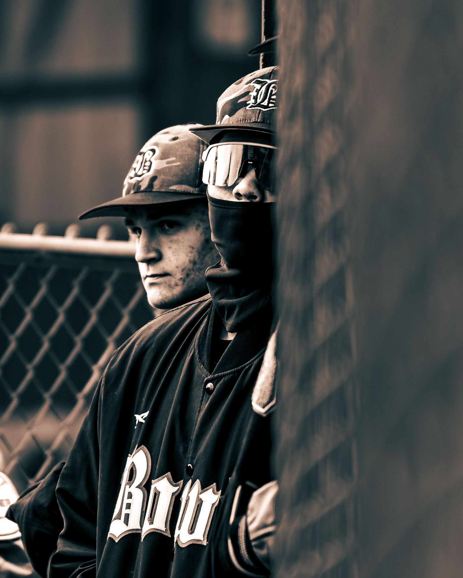 Baseball player leaning on the dugout fence, black and white