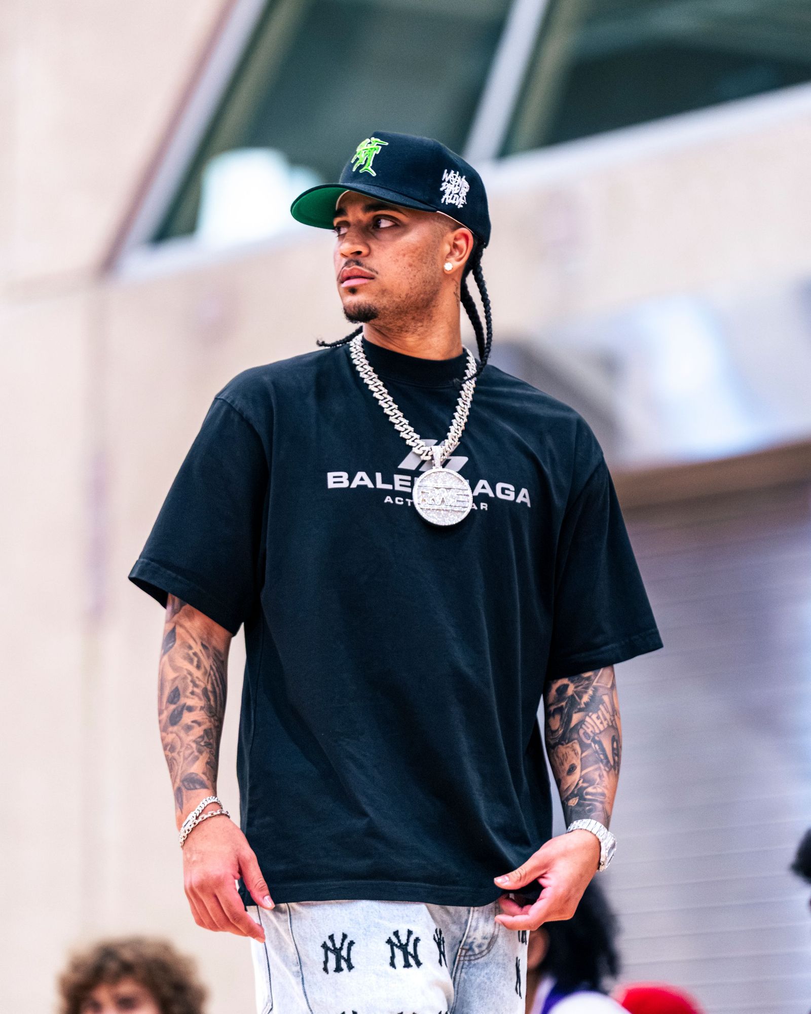 Athlete in a black t-shirt and chain arriving before the game