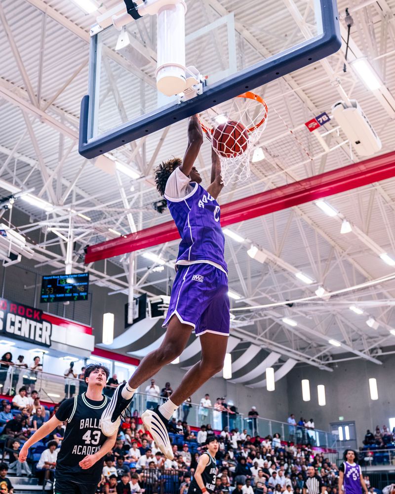 Basketball player dunking in a packed gym