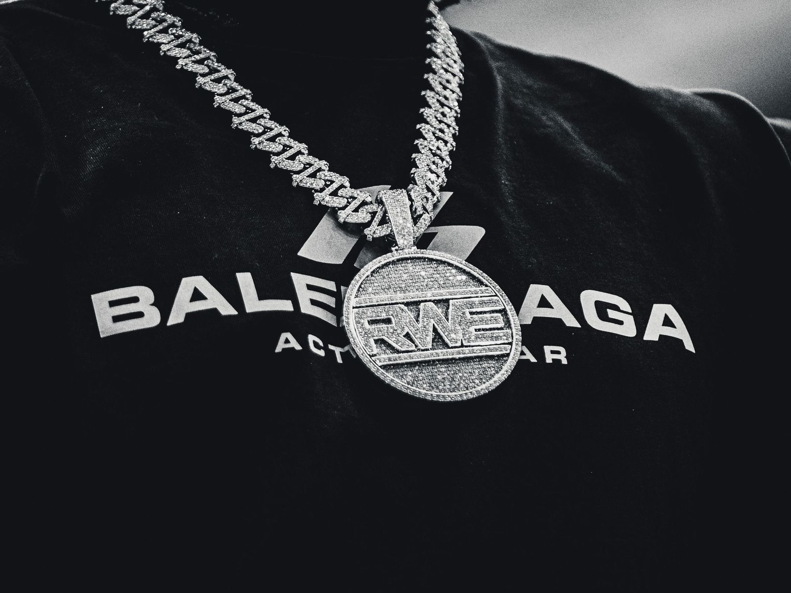 Close-up of a medallion on a chain against a black shirt