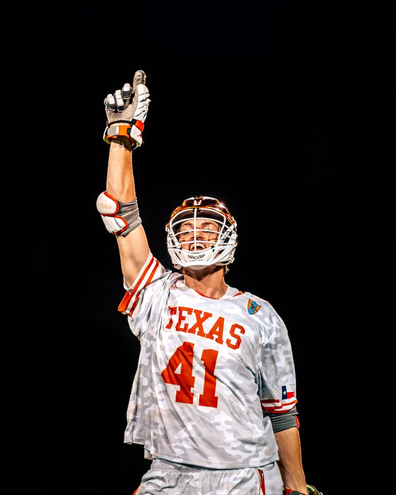 Texas lacrosse number 41 pointing to the sky after a goal