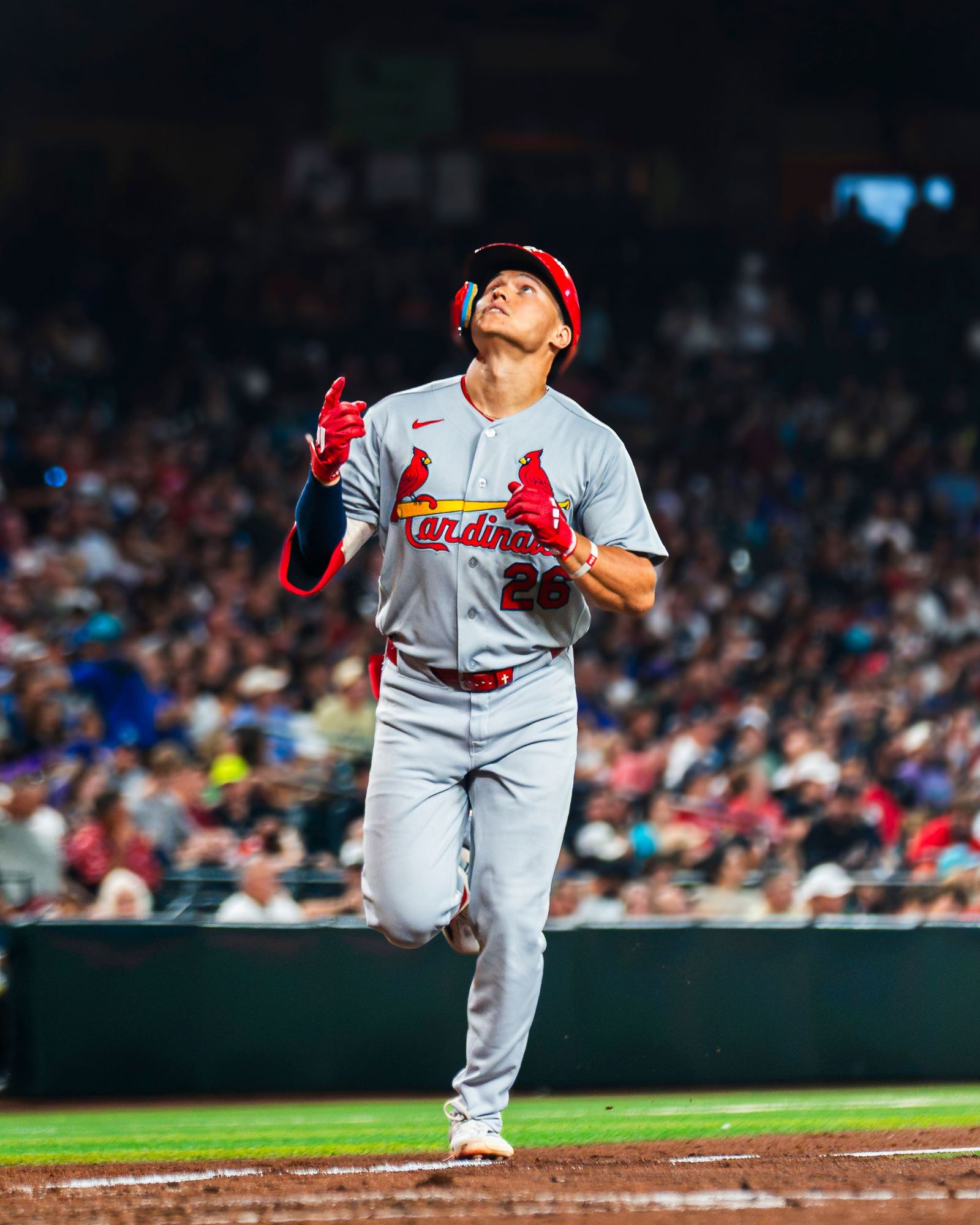Cardinals player jogging off the field at a full stadium