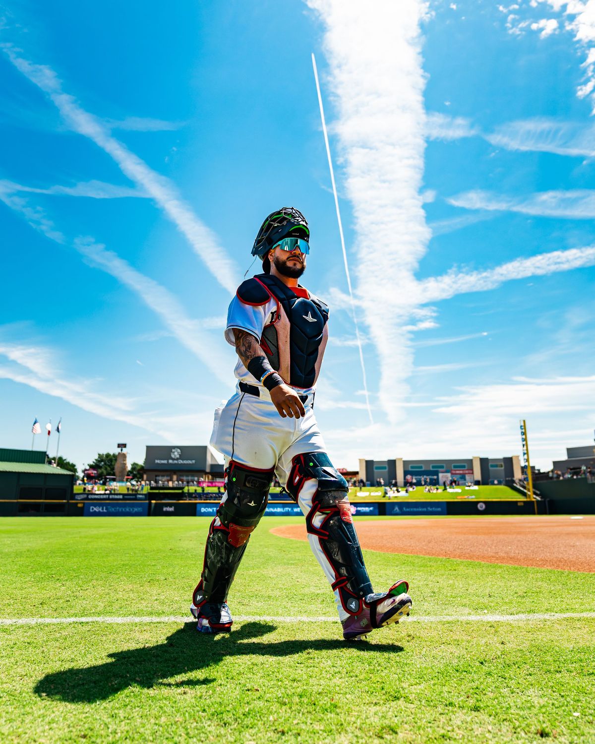 Catcher in full gear standing under a big sky