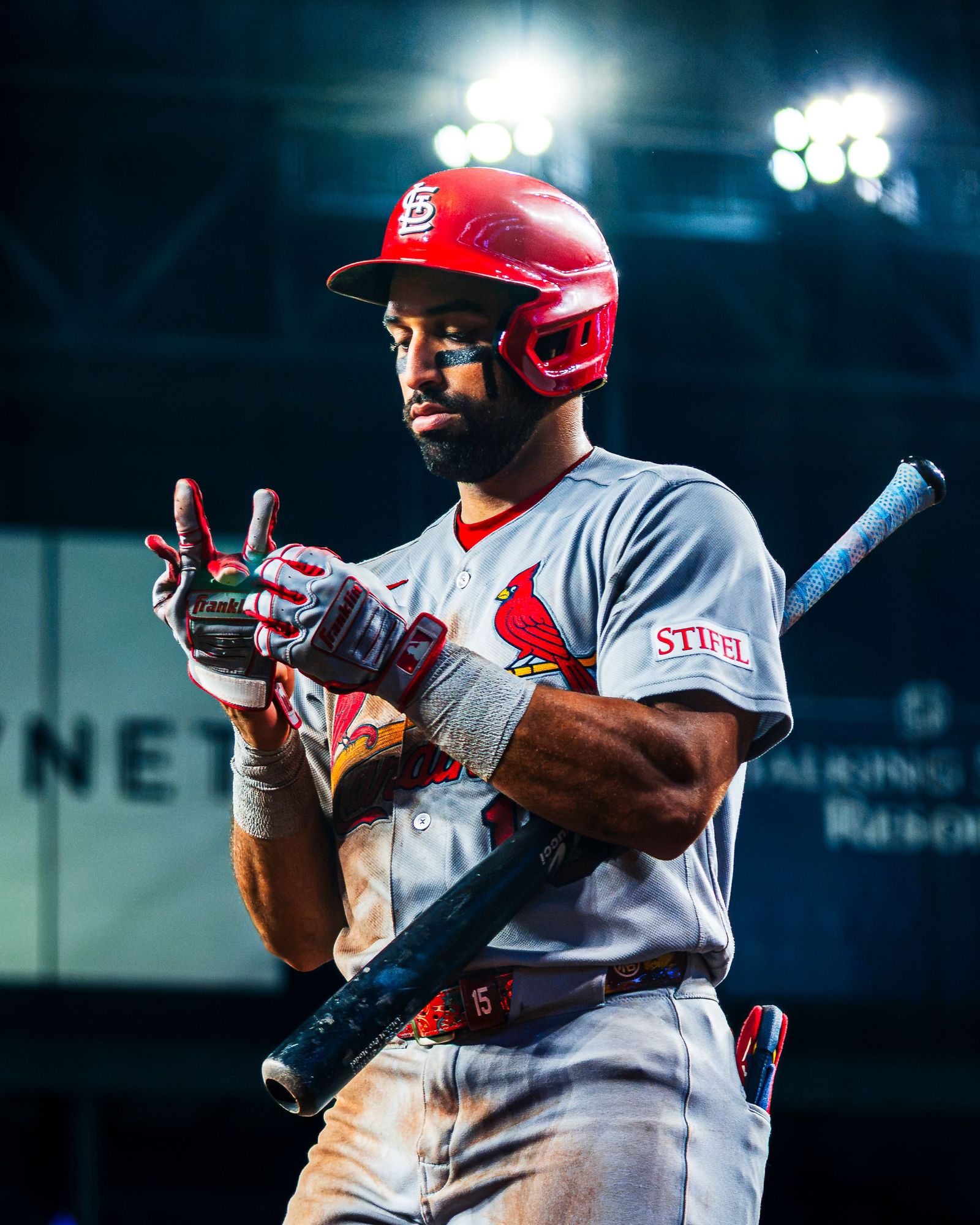 Cardinals batter with the bat on his shoulder under the lights