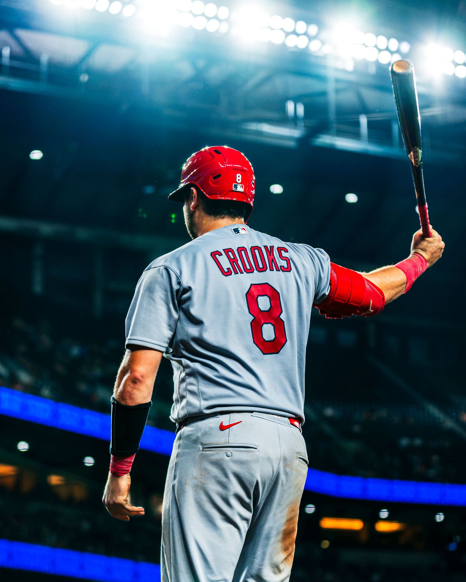 Cardinals player Crooks raising his bat to the crowd