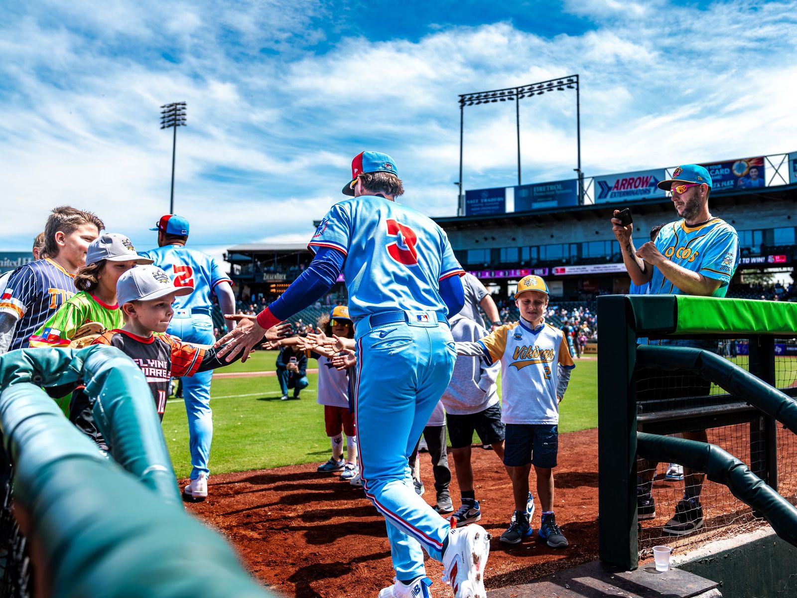 Round Rock Express player high-fiving young fans