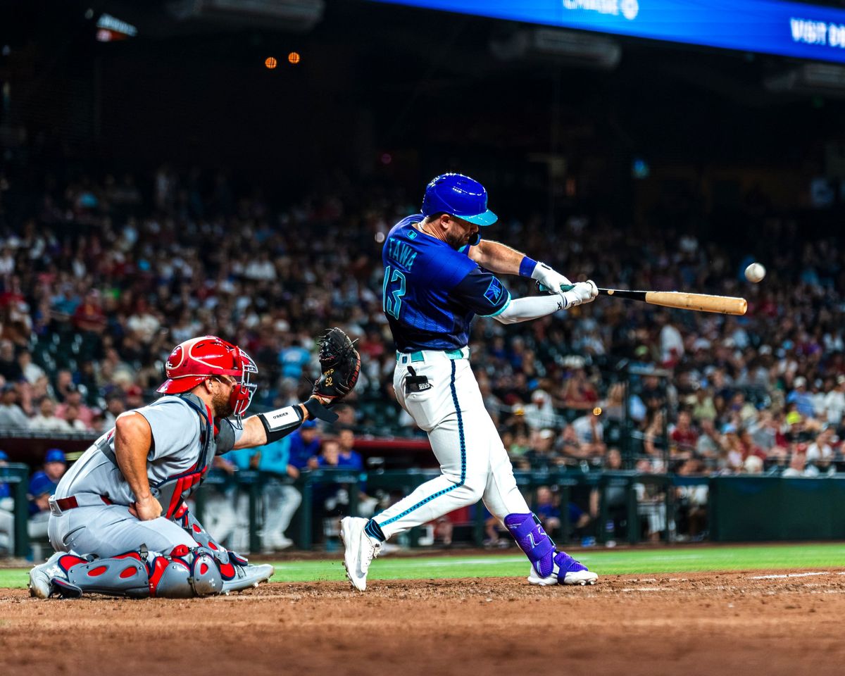 Batter connecting on a pitch as the catcher watches
