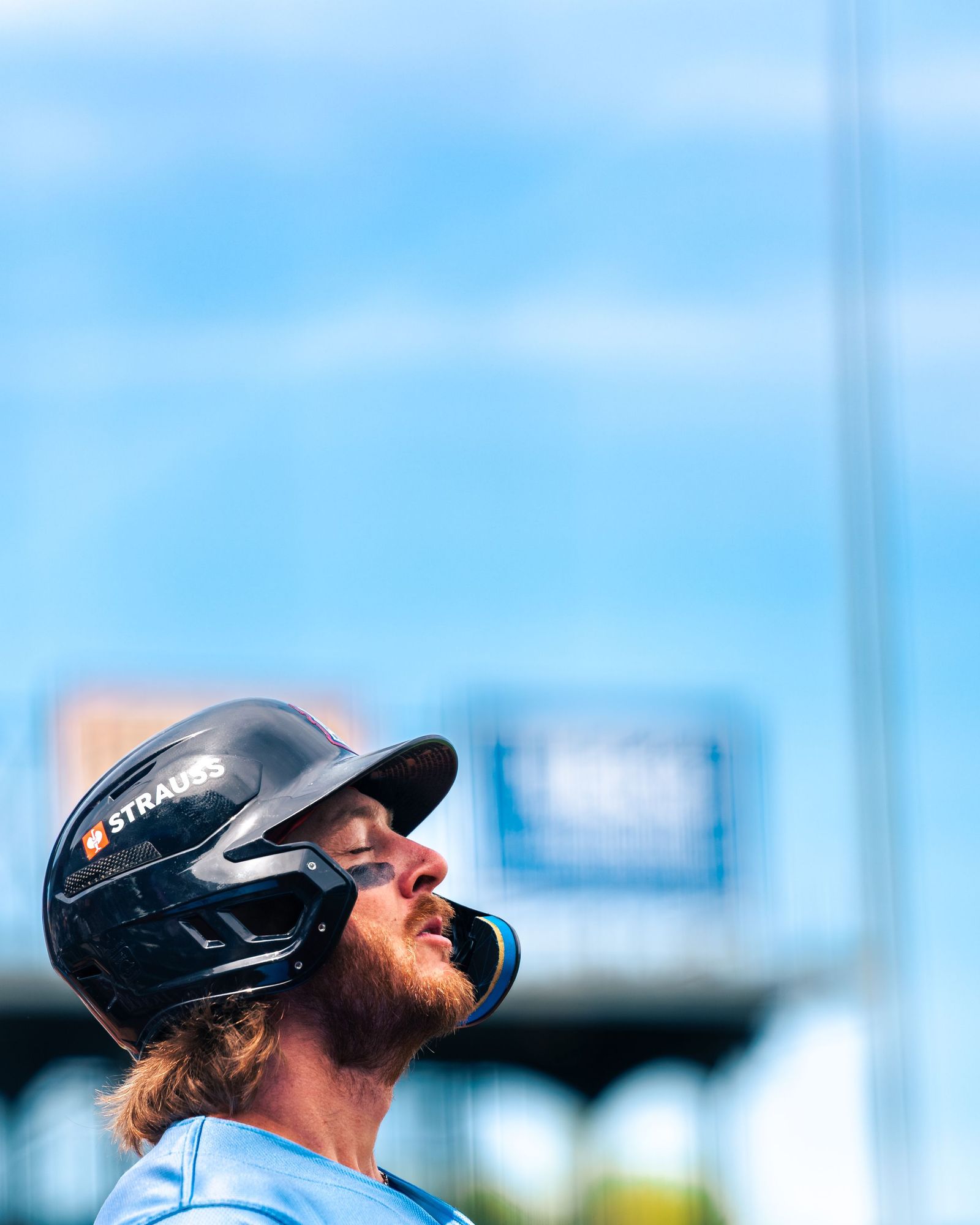 Batter in a helmet looking up at the sky