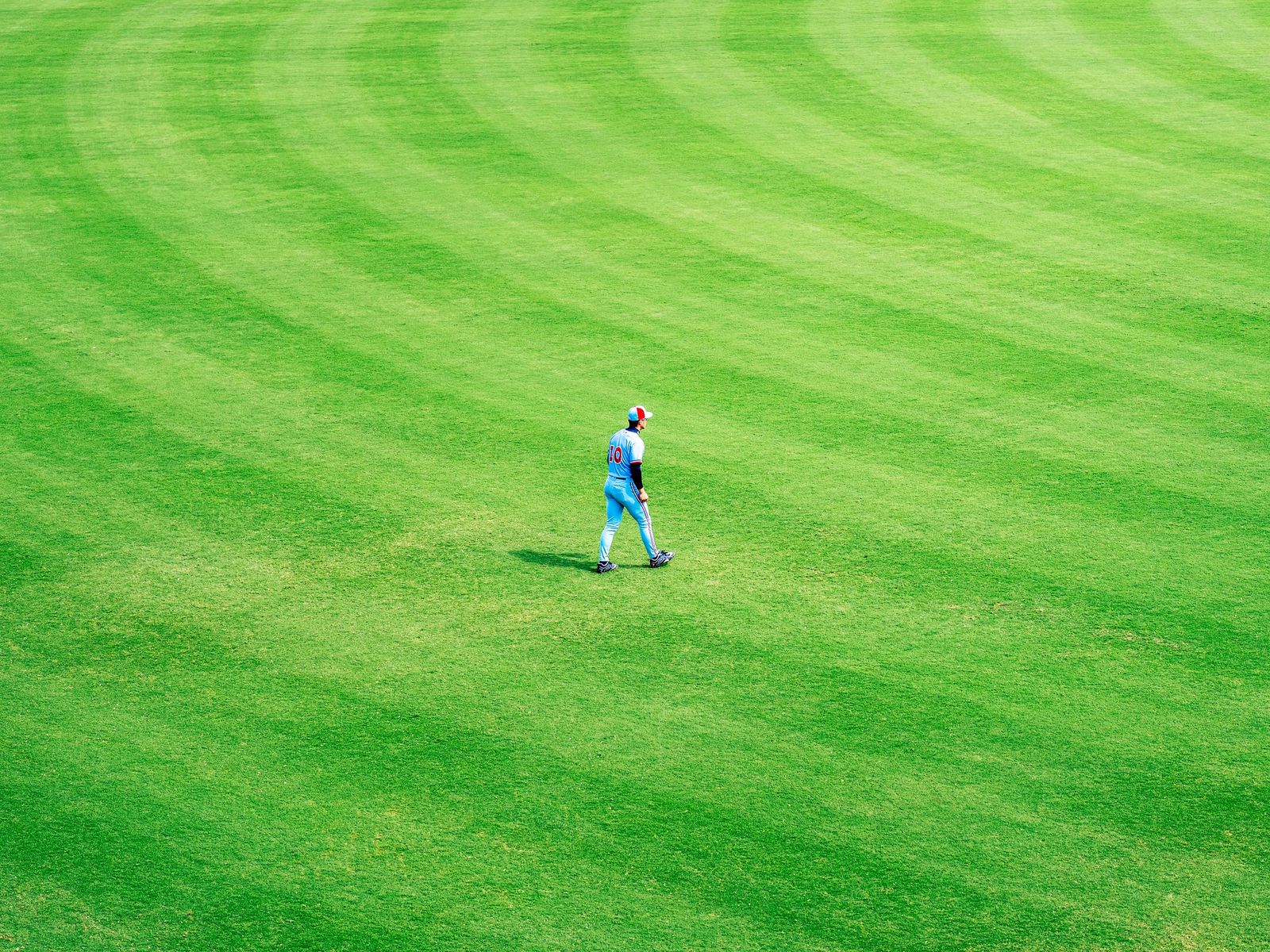 Outfielder standing alone on a wide green field