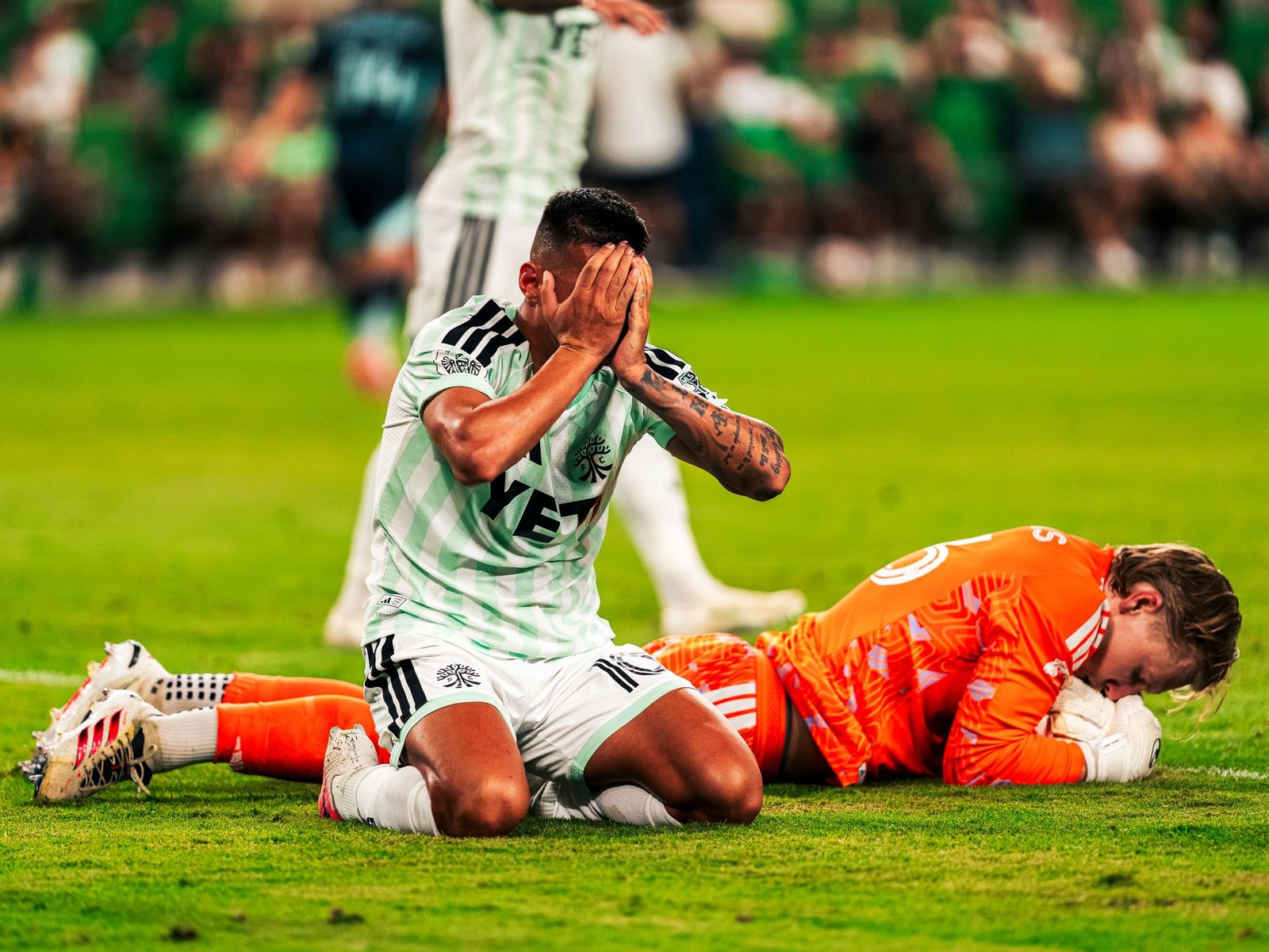 Austin FC player down as the goalkeeper covers the ball