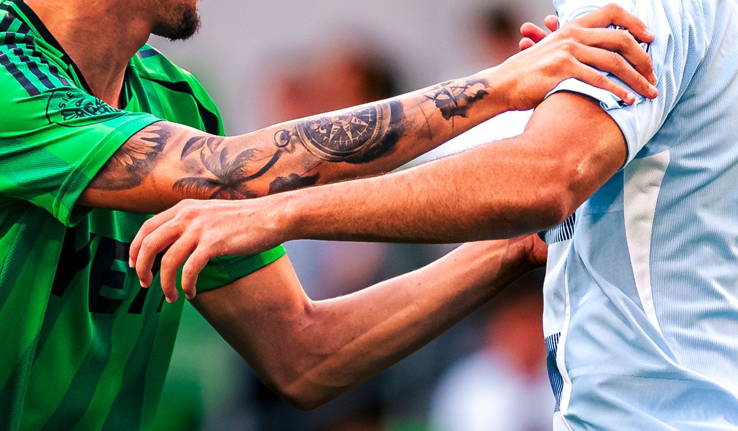 Tattooed arms grabbing a jersey in a challenge