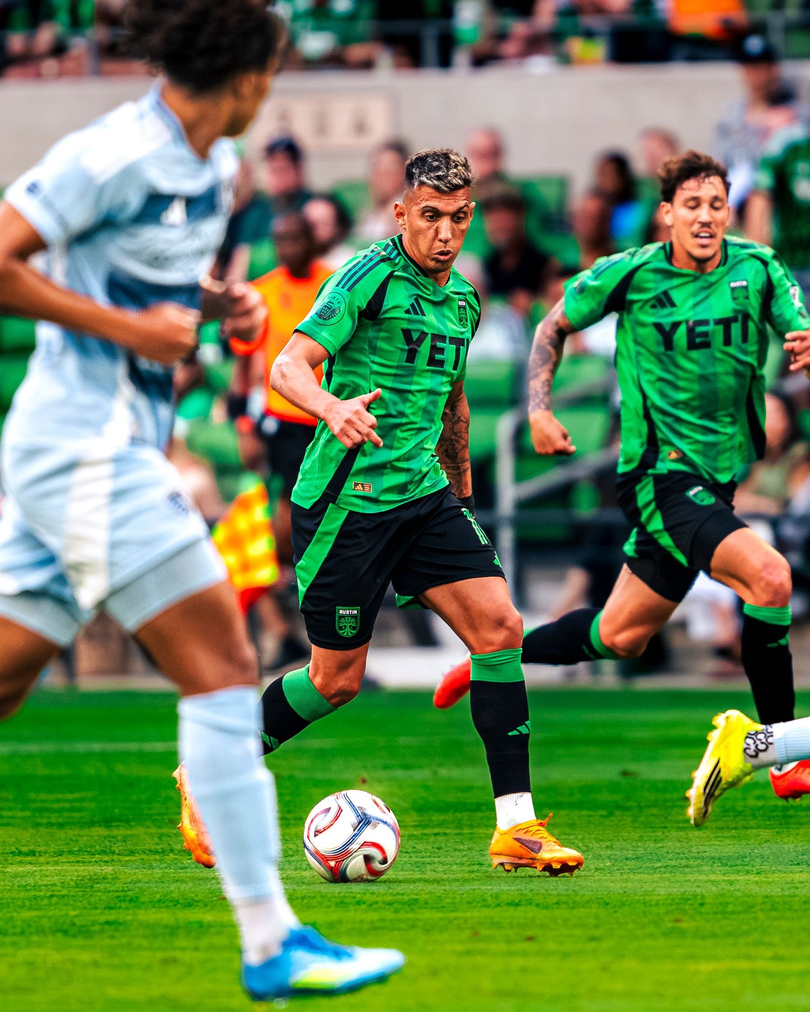 Austin FC player dribbling past a Sporting KC defender