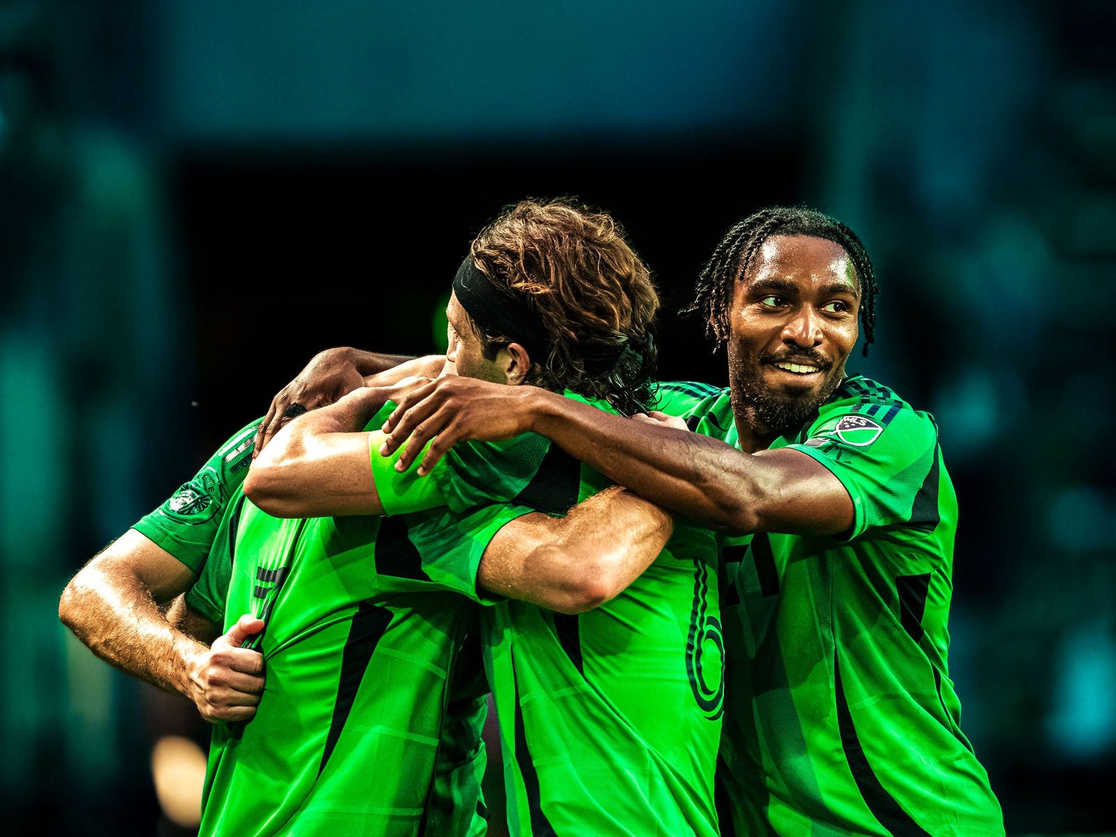 Austin FC players embracing after a goal