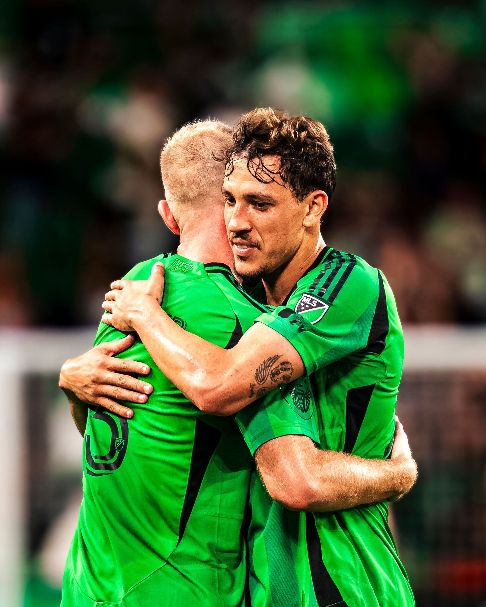 Two Austin FC players embracing