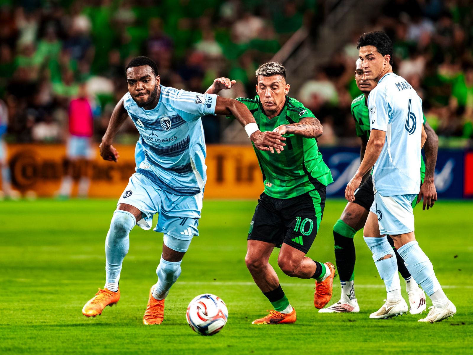Austin FC and Sporting KC players chasing a loose ball