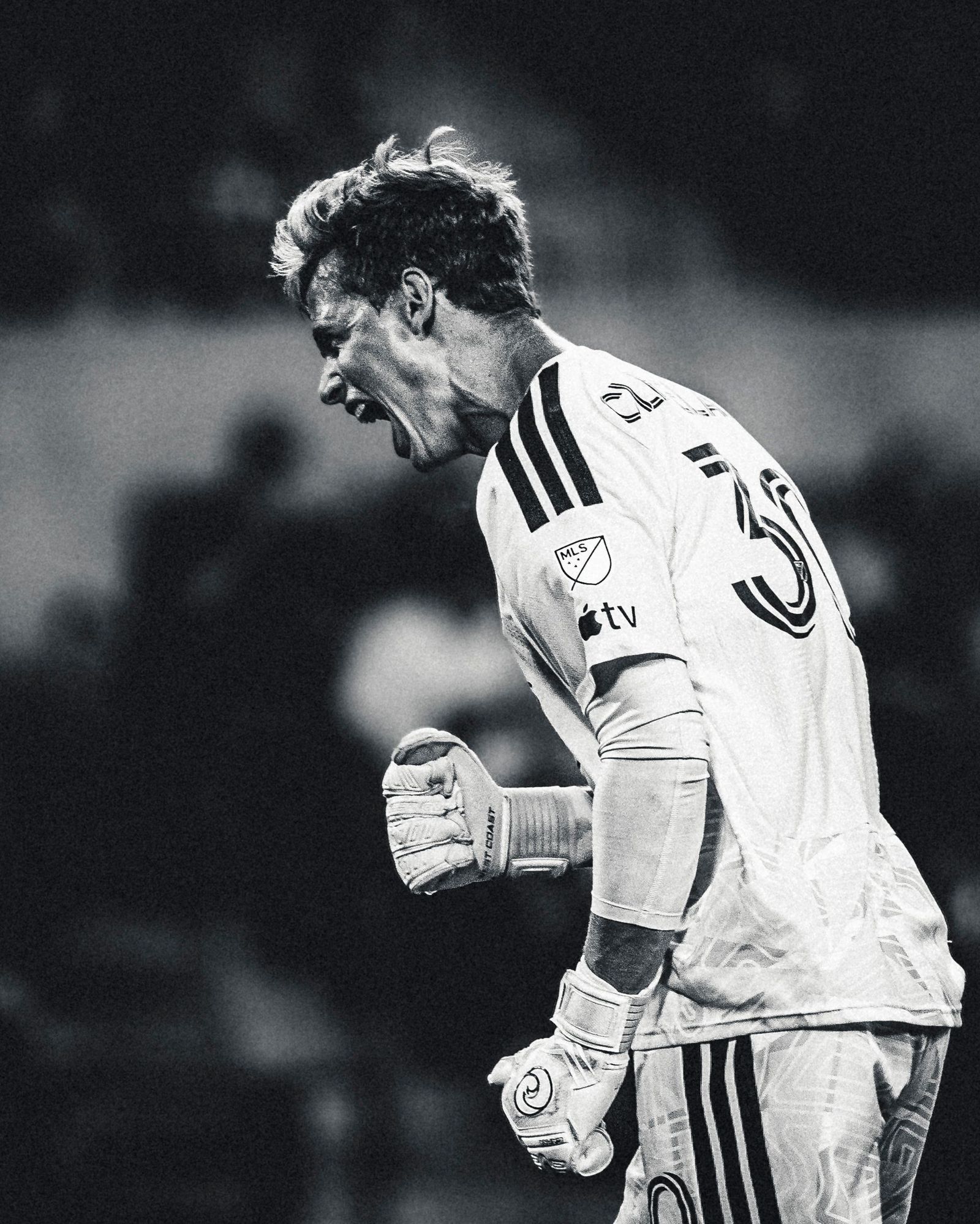 Goalkeeper roaring after a save, black and white