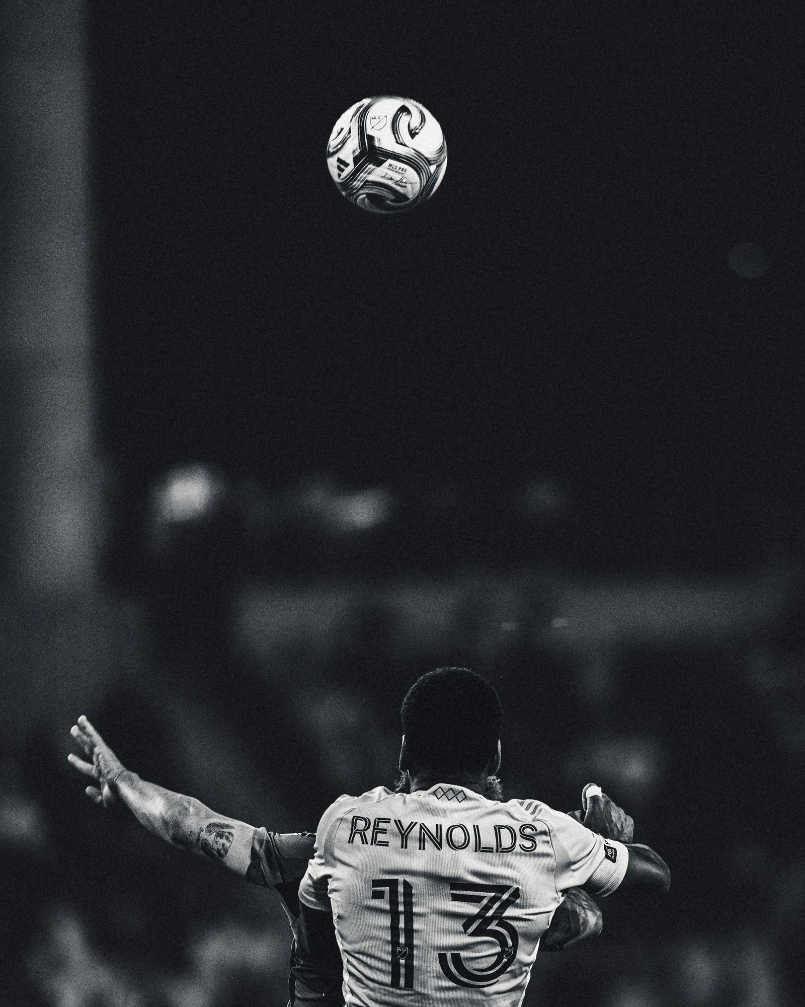 Player number 13 watching a ball in the air, black and white