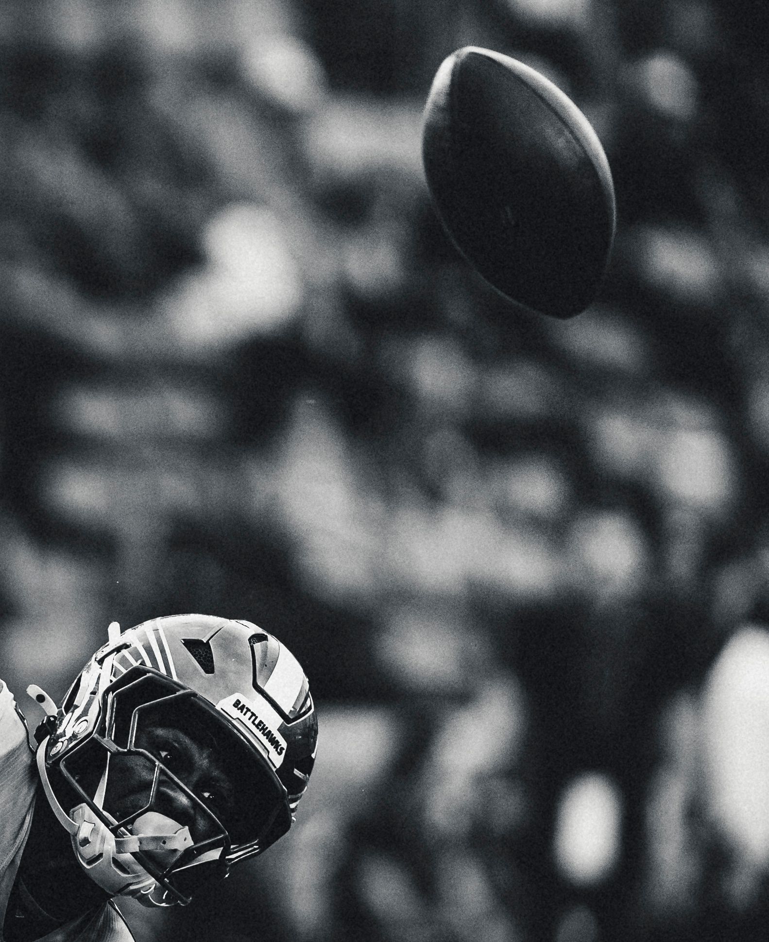 Football helmet and ball in the air, black and white