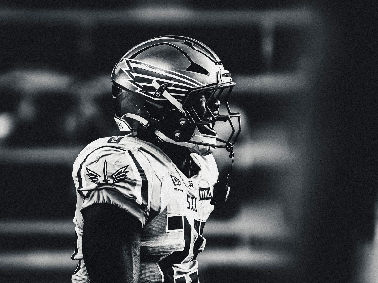 Football helmet under stadium lights, black and white