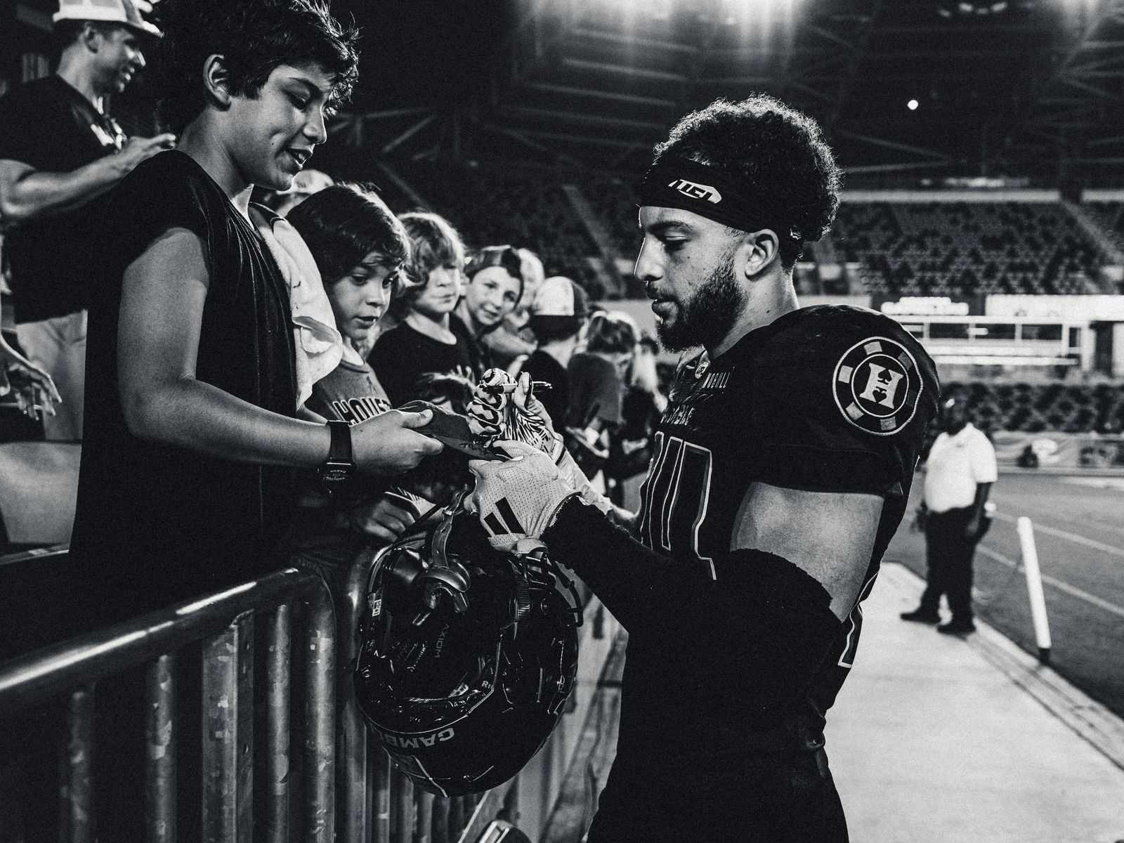 Players signing autographs for fans, black and white