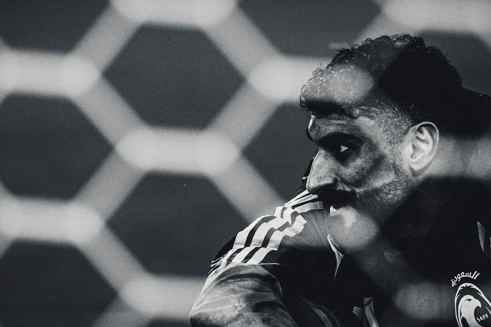 Goalkeeper behind the net, black and white