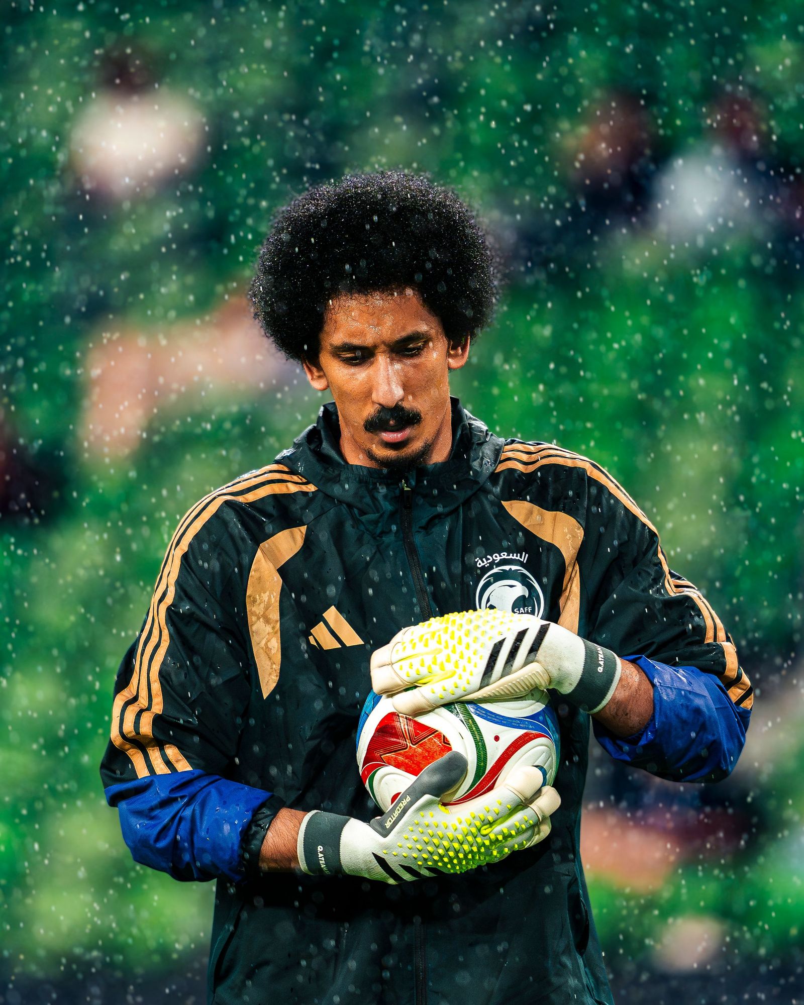 Goalkeeper in the rain clutching the ball