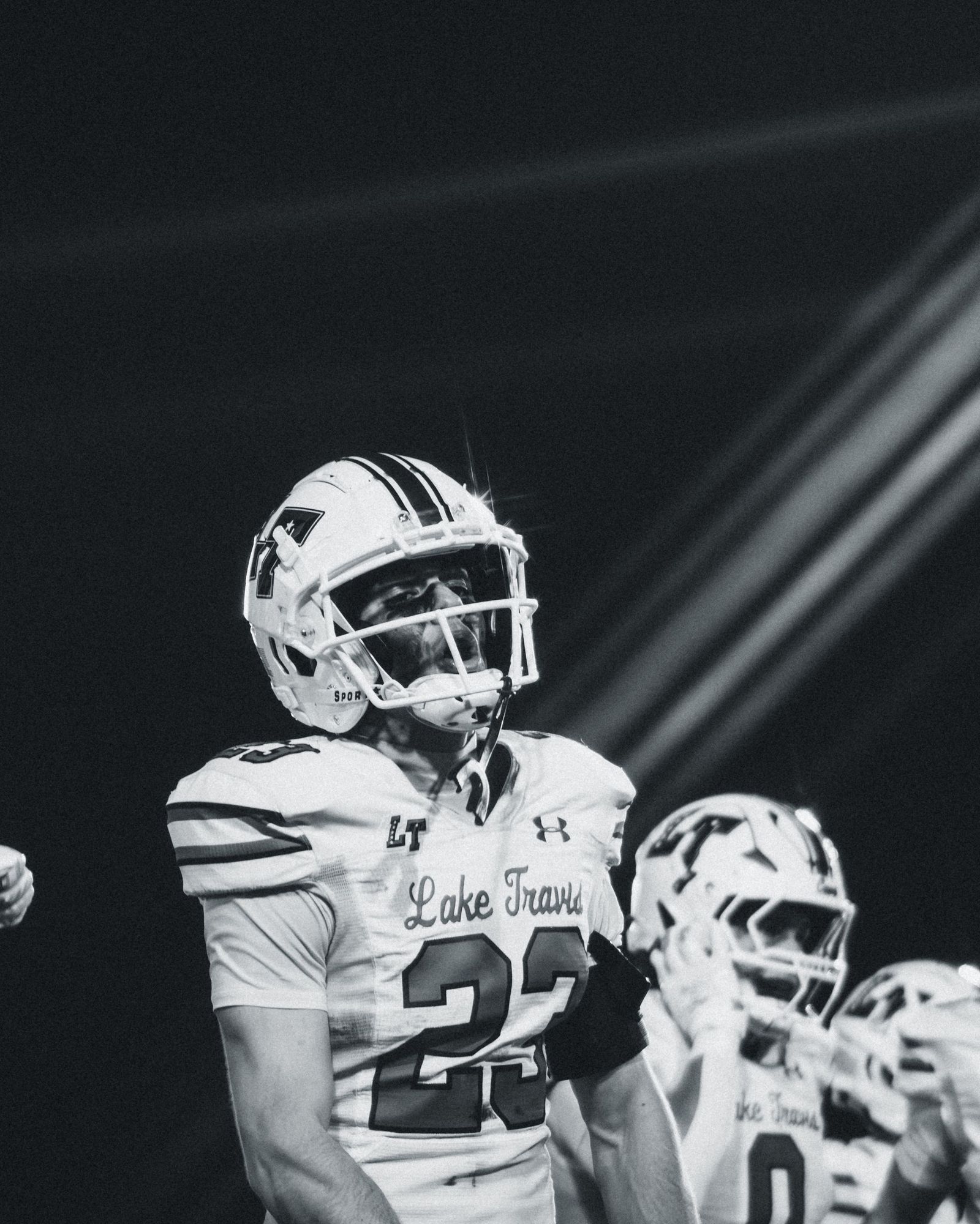 Lake Travis football players under the lights, black and white