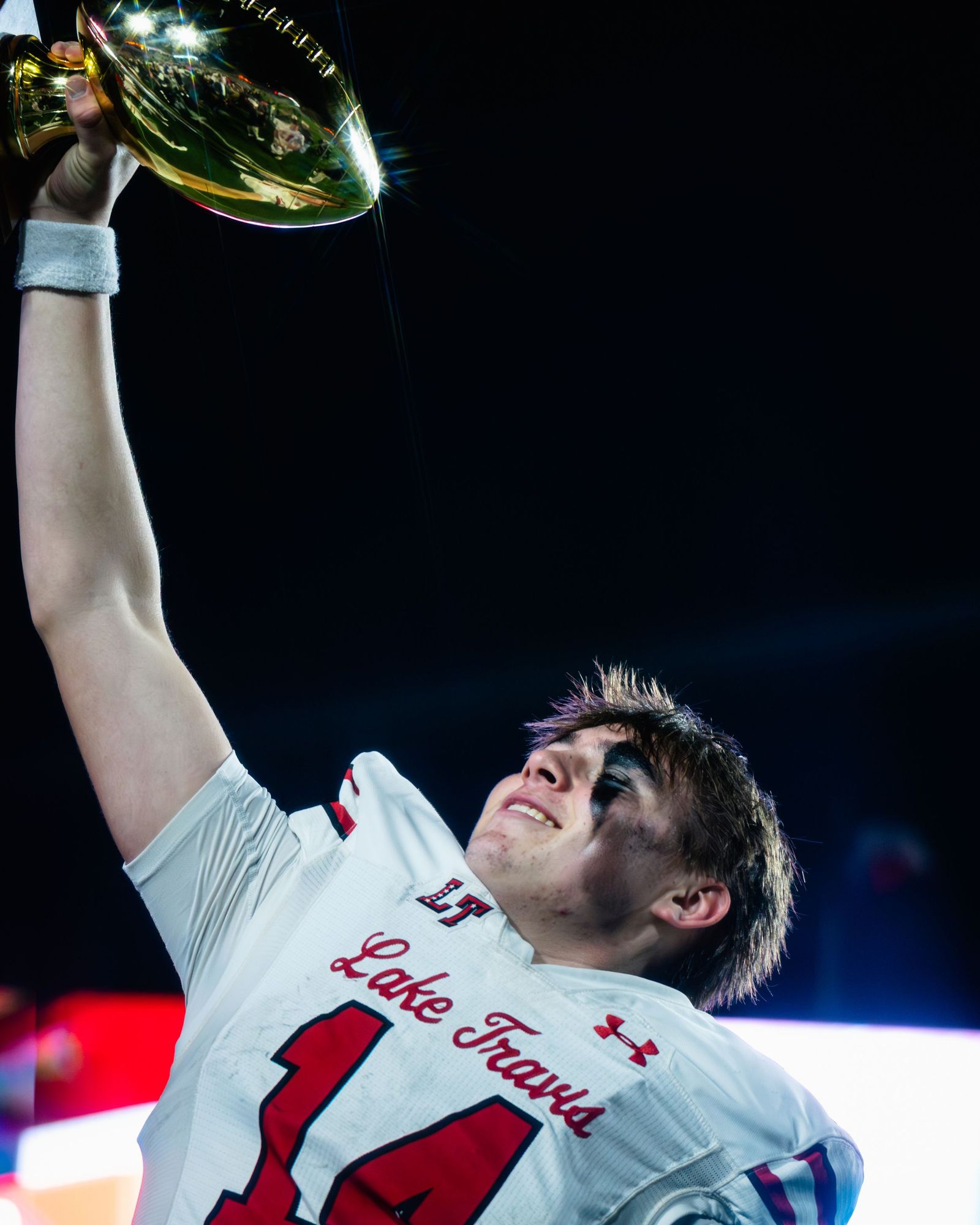 Lake Travis player raising a championship trophy
