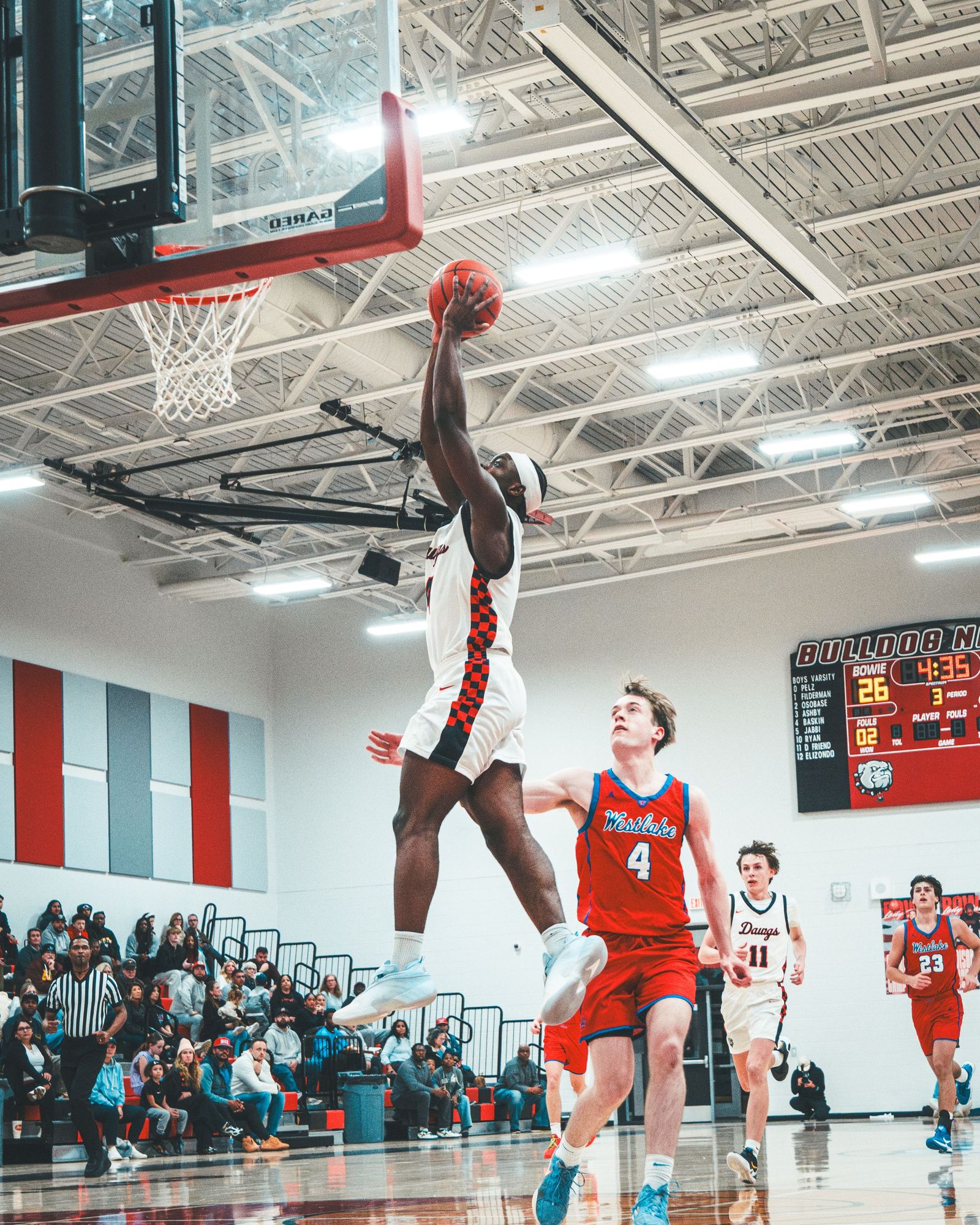Basketball player rising for a dunk in a school gym