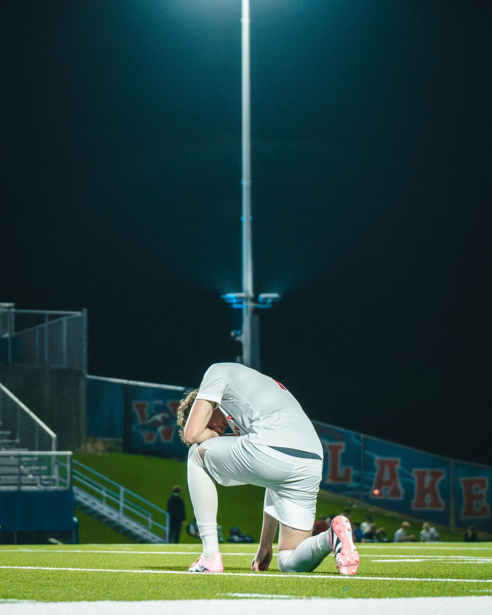Soccer player kneeling on the field after the match