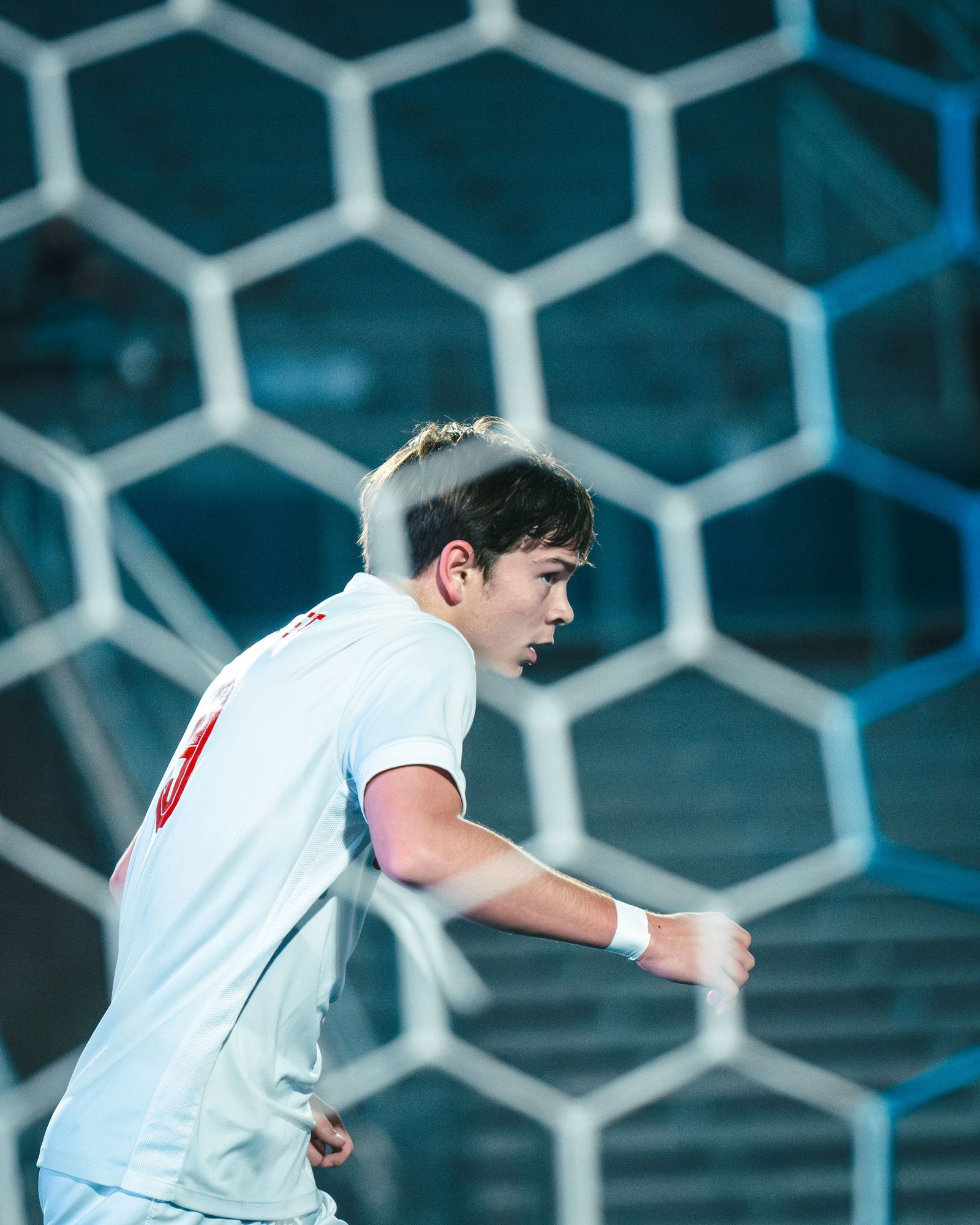 Soccer player in white inside the goal net