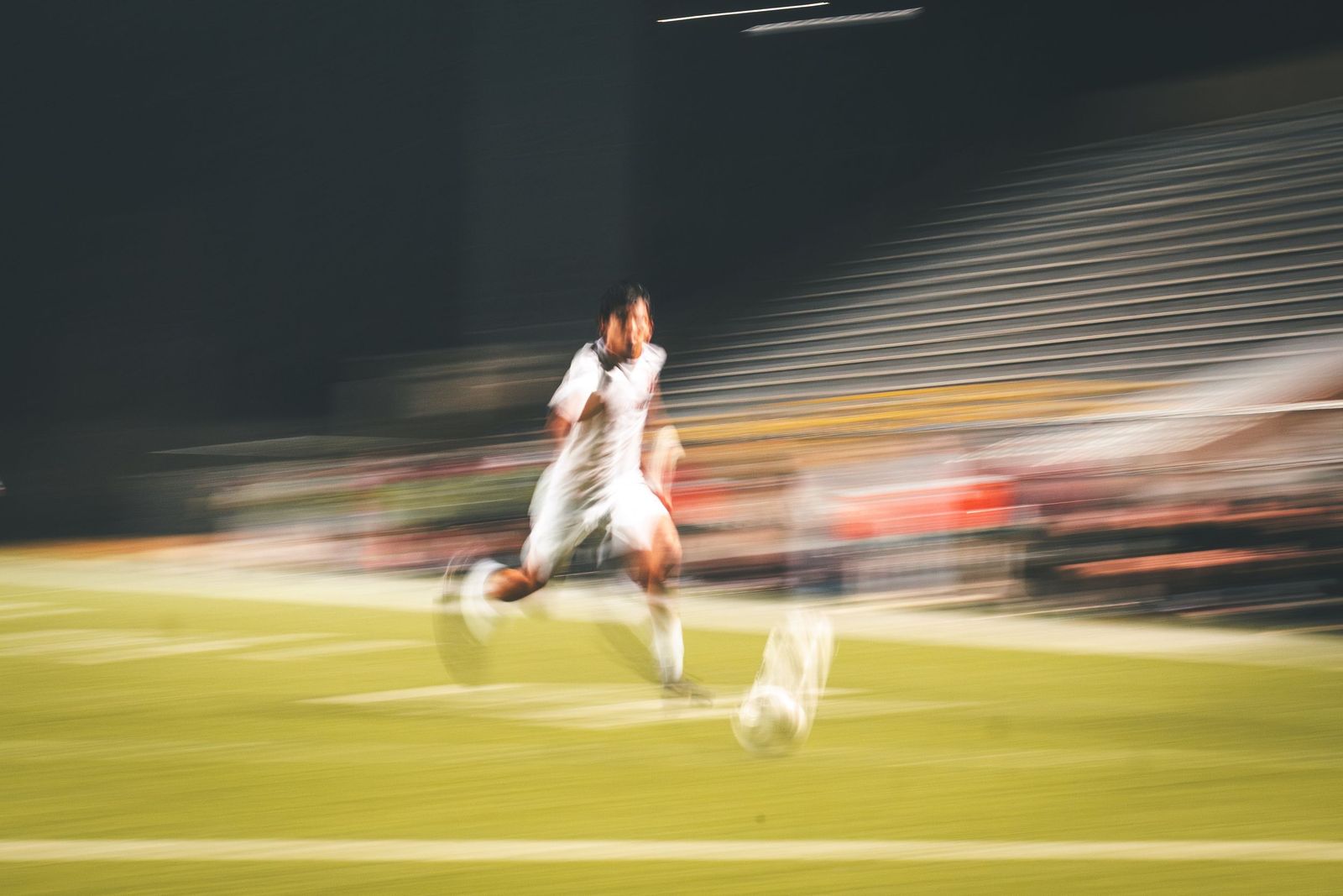 Soccer player in a blur of motion at night