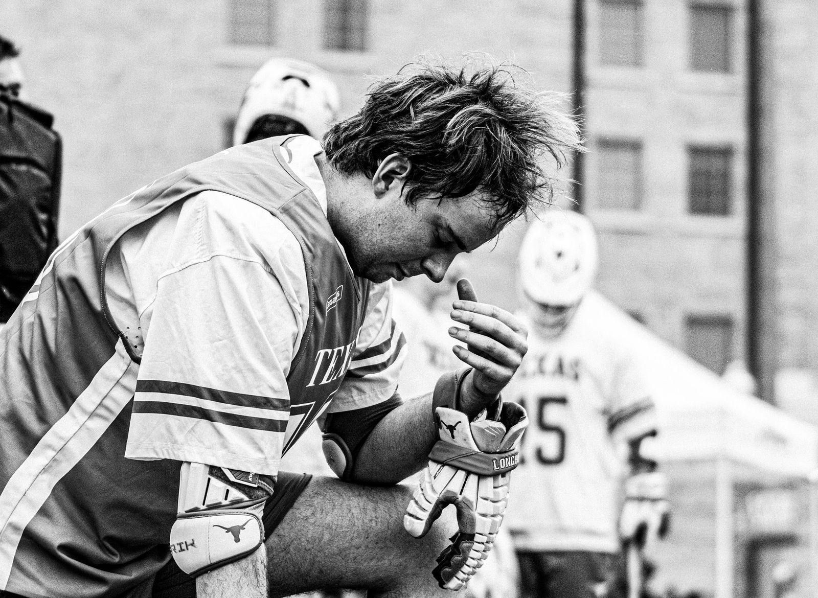 Lacrosse players huddled before the game, black and white