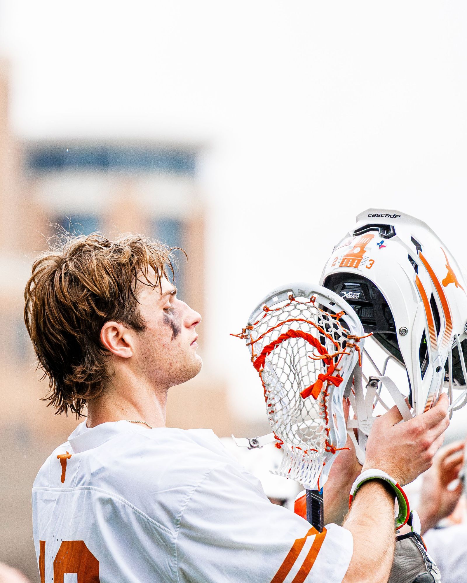 Lacrosse player holding his stick and helmet