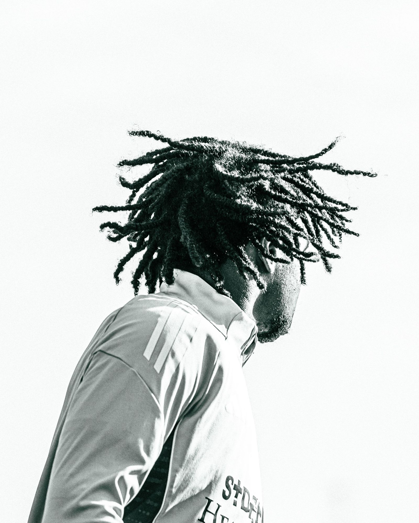 Player with locs in a white jersey seen from behind