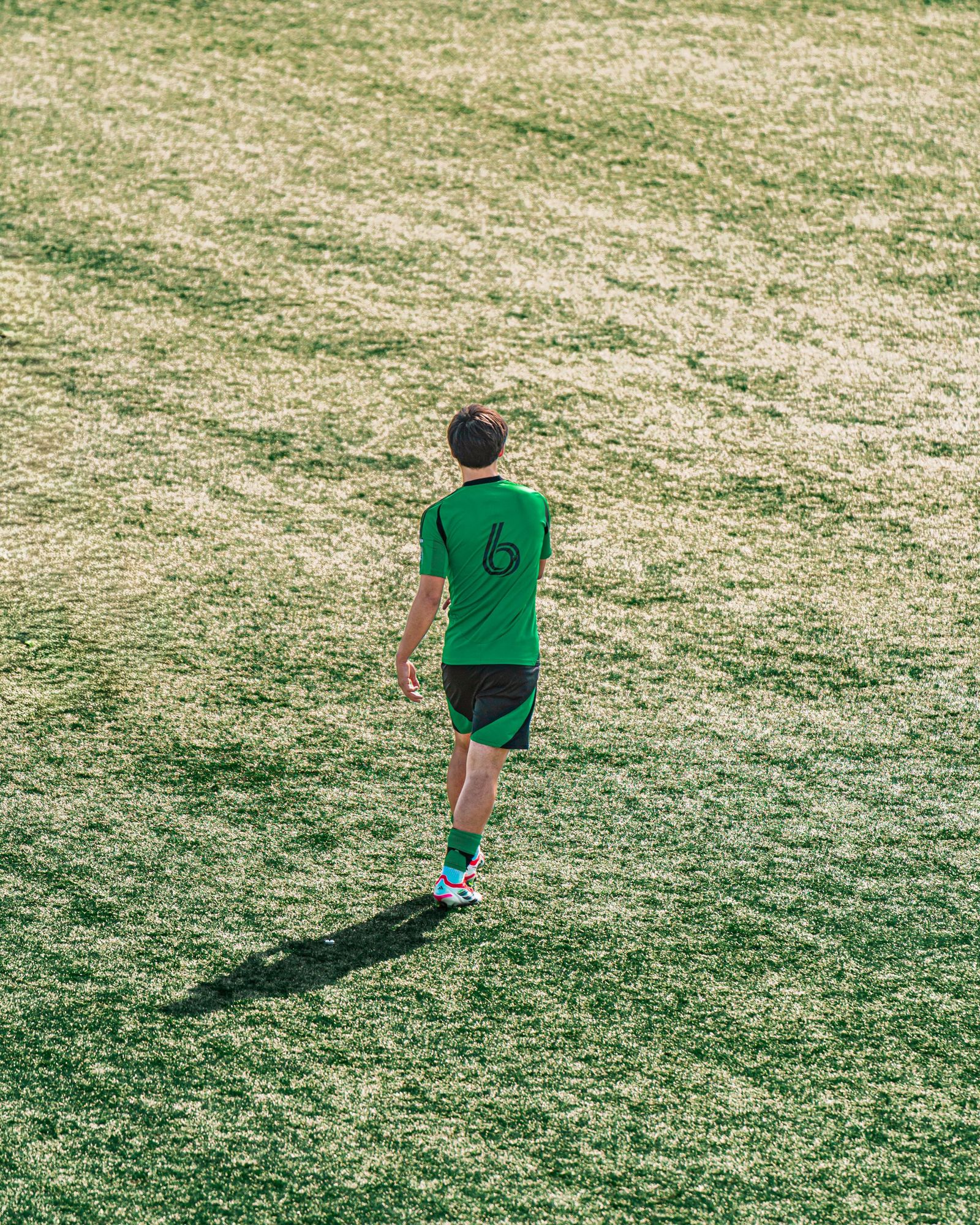 Young player walking alone across the field