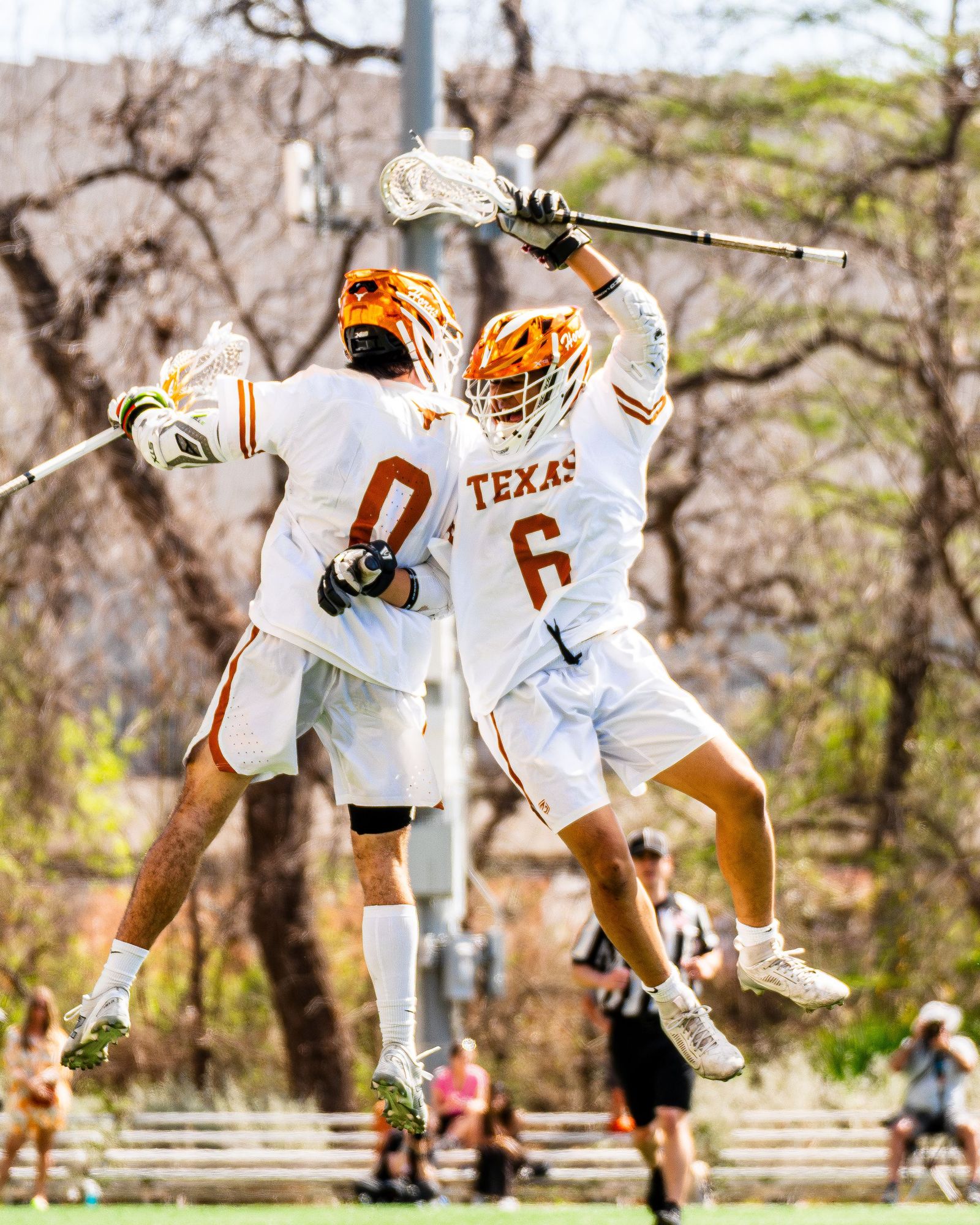 Texas lacrosse teammates leaping into each other in celebration