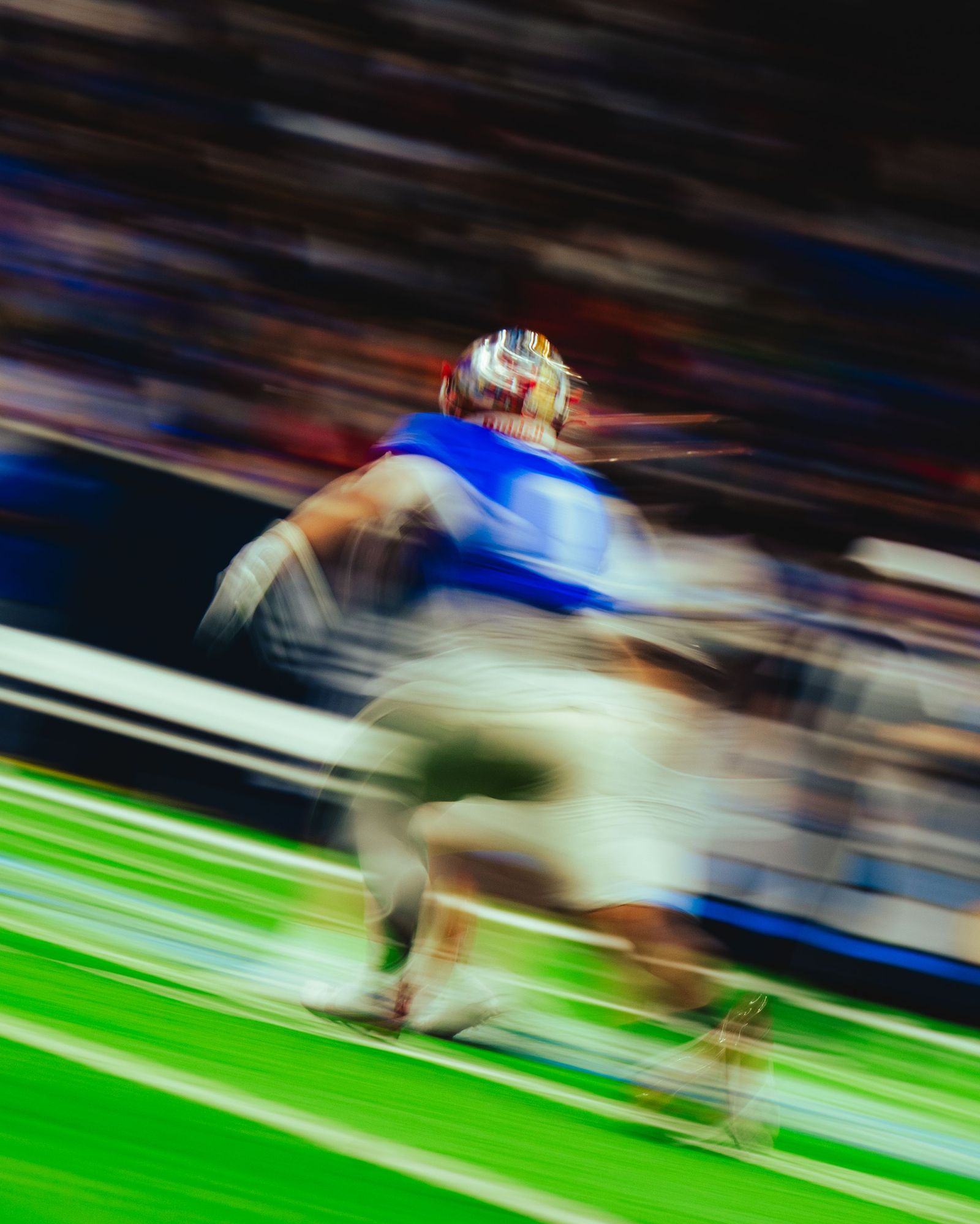 Ball carrier blurring past the sideline
