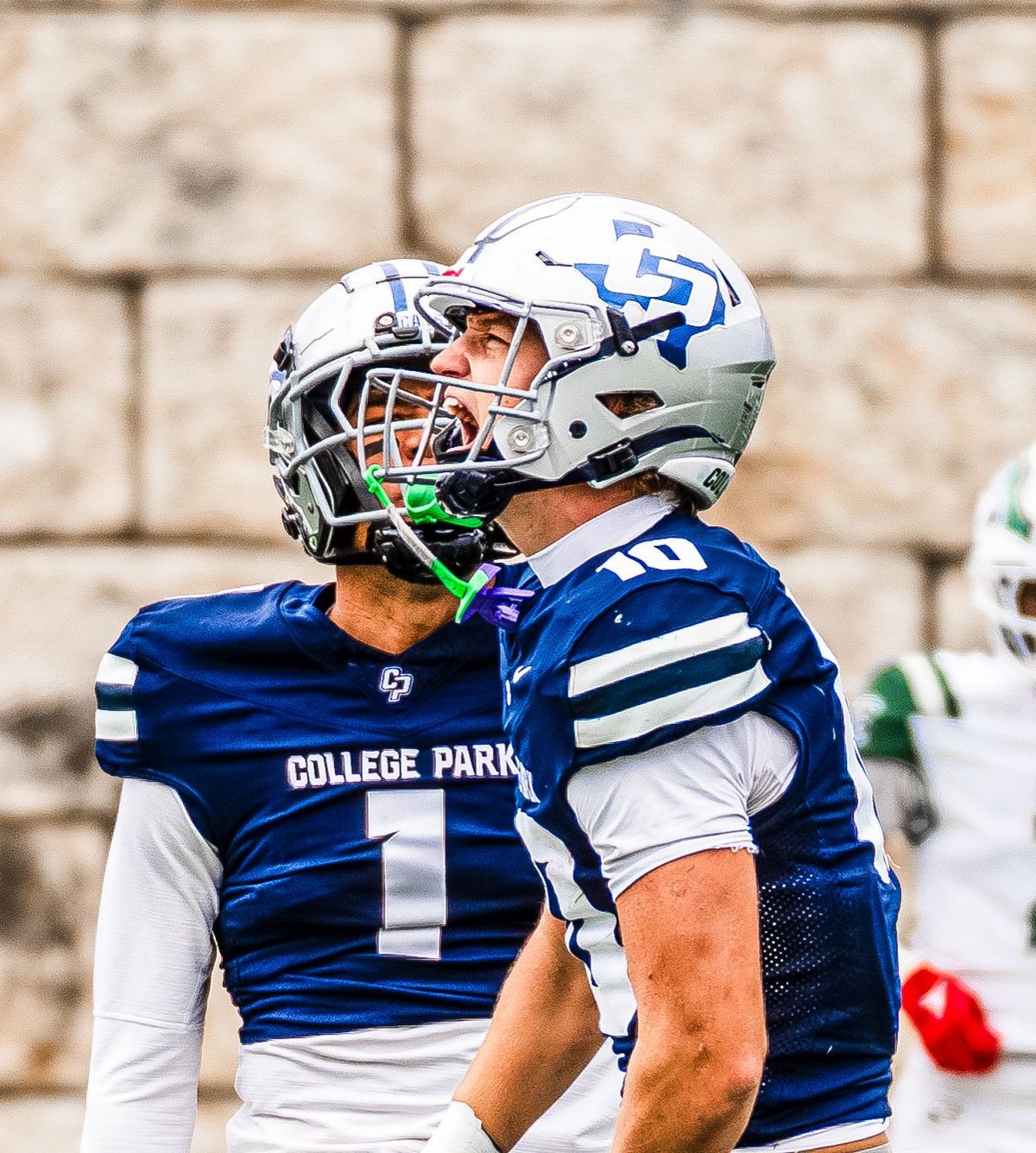 College Park quarterback in blue shouting on the sideline