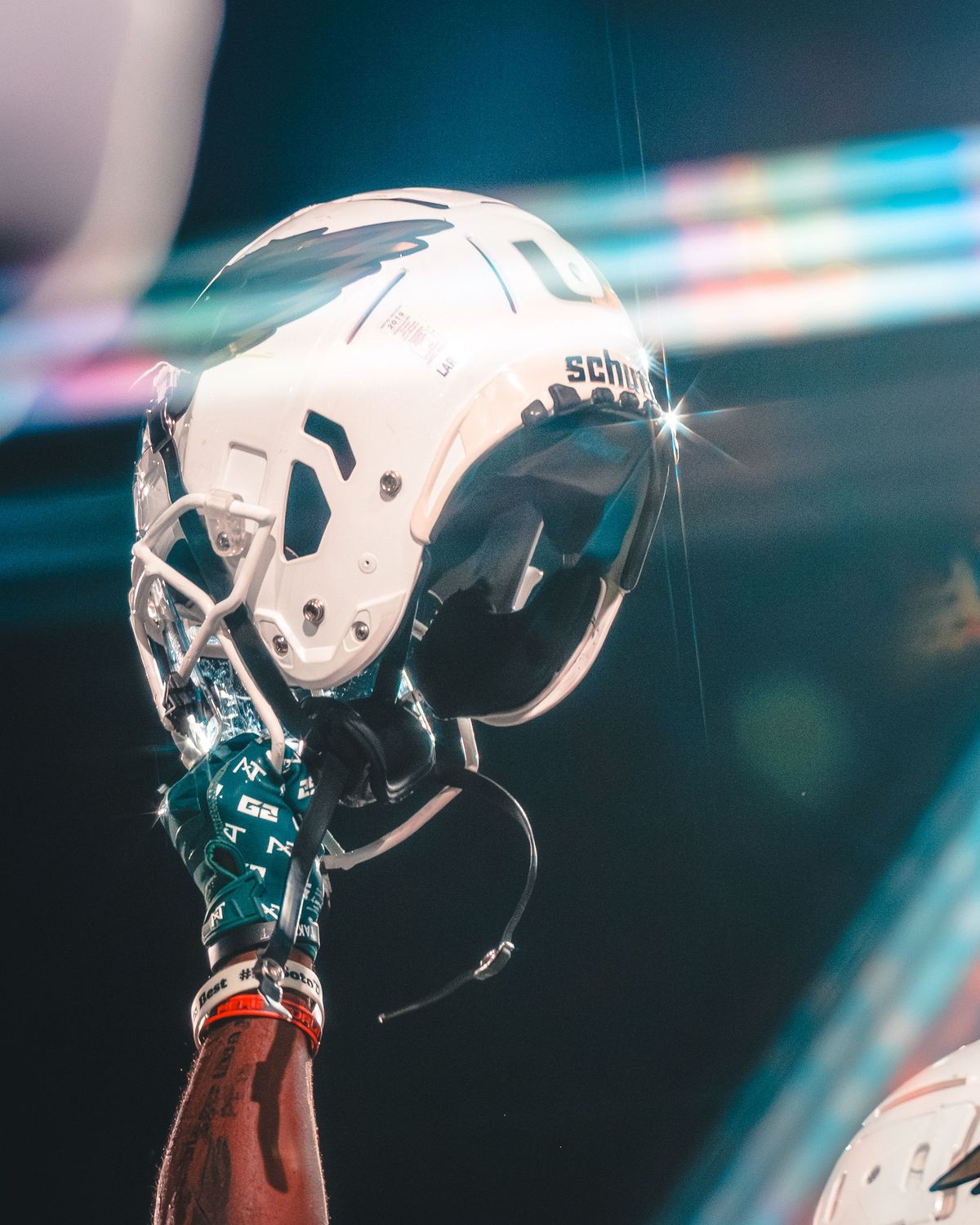 Championship trophy reflected in a football helmet under stage lights