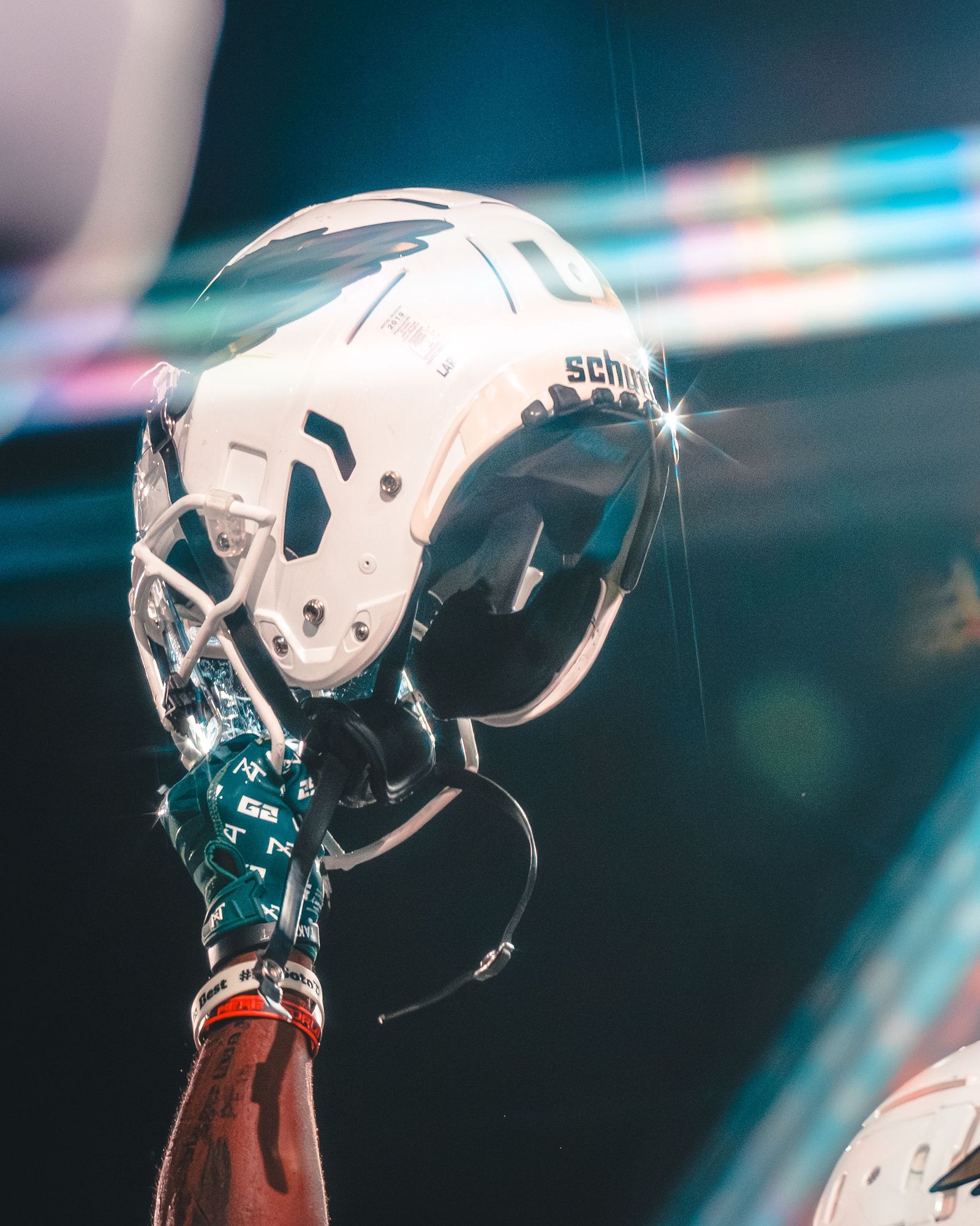 Championship trophy reflected in a football helmet under stage lights